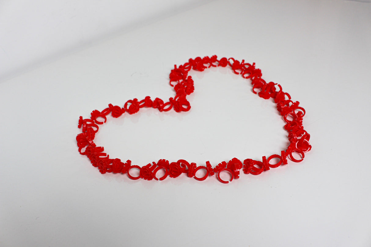 Red heart-shaped glue rings – lash adhesive holders arranged in a heart layout by Trish Co Red heart-shaped glue rings – lash adhesive holders arranged in a heart layout by Trish Co