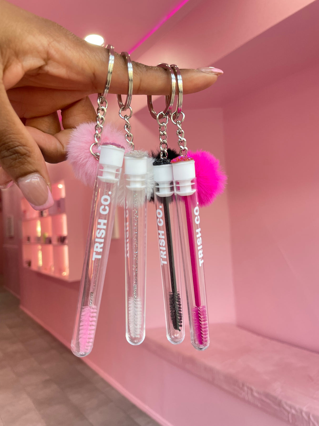 Group shot of Brush & GO keychain spoolies – travel lash brushes in white, black, and pink from Trish Co Group shot of Brush & GO keychain spoolies – travel lash brushes in white, black, and pink from Trish Co